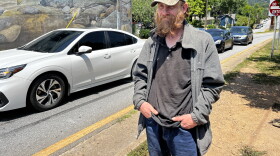 Justin Williams, a routine panhandler, stands at the corner of Montford Avenue and Cherry Street near downtown Asheville.