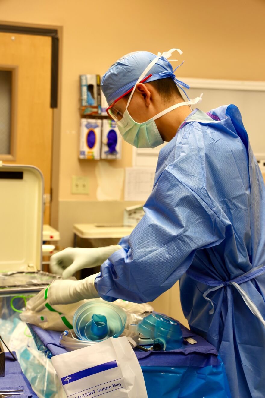 Brandon Vazquez, a YRMC Surgical Tech intern, prepares instruments for a robotic surgery,