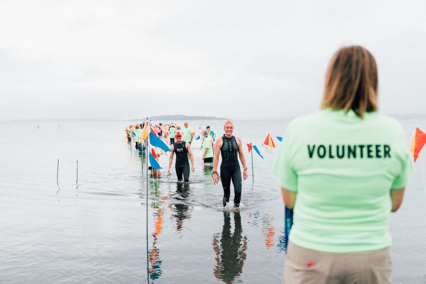 A swimmer crosses the finish line in Jamestown during the 2024 Save the Bay Swim.