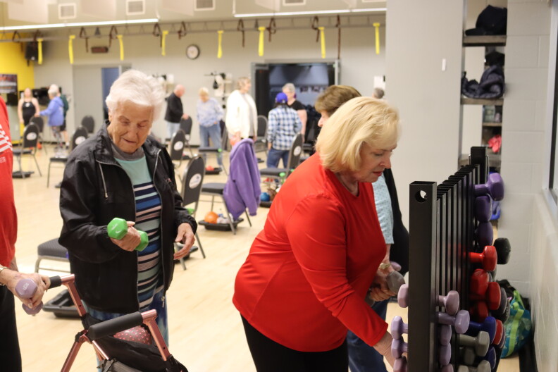 Adults grab weights from a weight rack at an Idaho YMCA.
