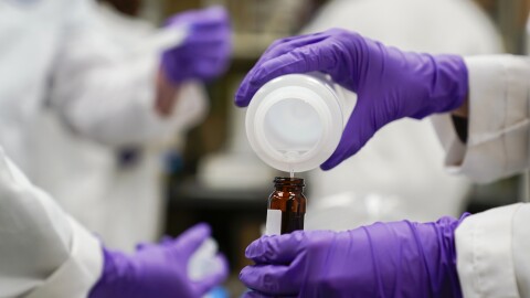FILE - Eva Stebel, water researcher, pours a water sample into a smaller glass container for experimentation as part of drinking water and PFAS research at the U.S. Environmental Protection Agency Center for Environmental Solutions and Emergency Response, Feb. 16, 2023, in Cincinnati. Wisconsin's Democratic Gov. Tony Evers signaled Wednesday, Feb. 21, 2024, that he has no intention of signing a Republican bill that would spend tens of millions of dollars to combat PFAS pollution because it dramatically scales back regulators' enforcement authority. (AP Photo/Joshua A. Bickel, File)
