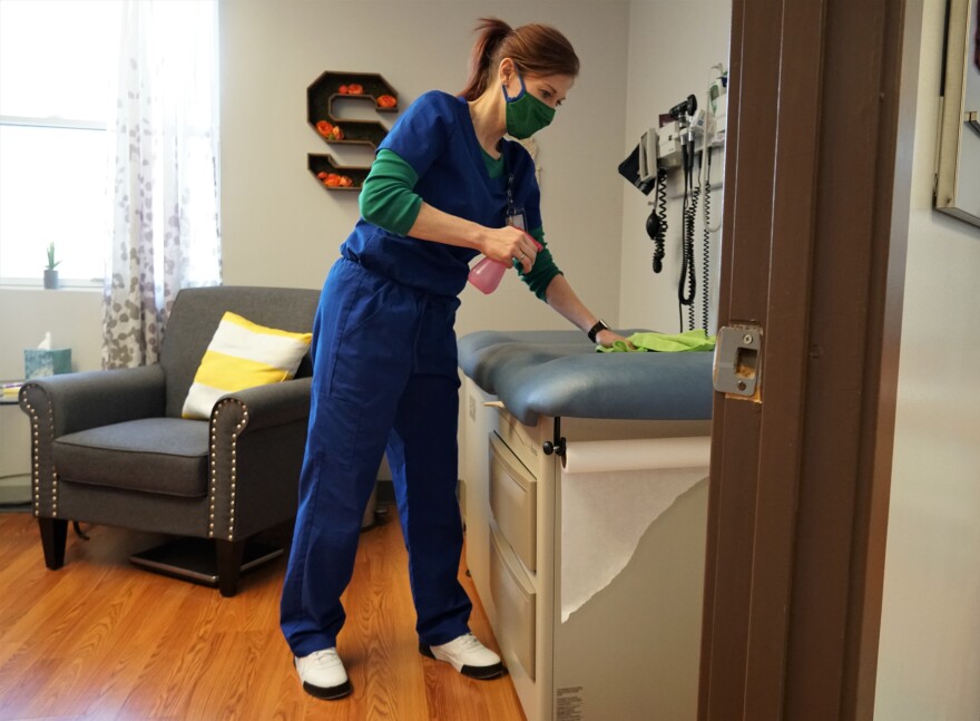 Dr. Andrea Otto disinfects an exam room the three-person sproutMD clinic in Kirkwood. Otto said small clinics such as hers have received little information from health officials on where and when they can receive the coronavirus vaccine. 