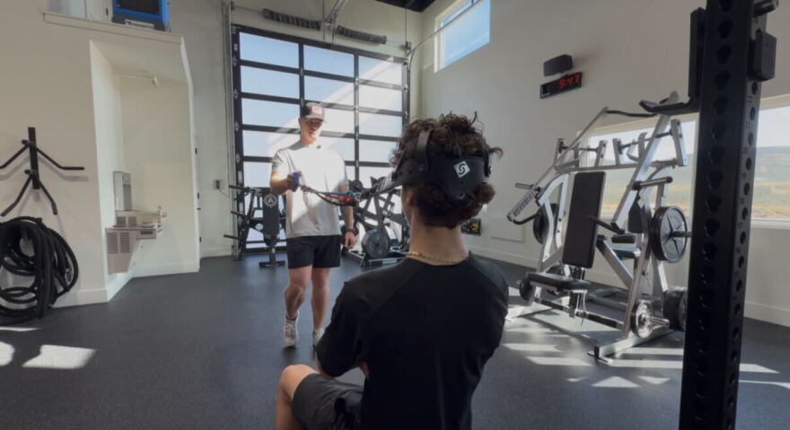 Maverick McKenna and his trainer Josh Wiles perform neck exercises at a gym in Park City.