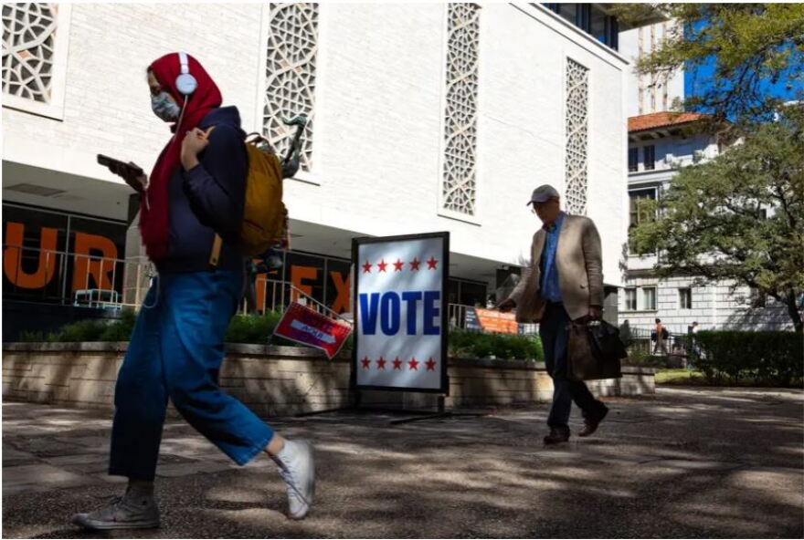 Students and faculty walk past the Peter T. Flawn Academic Center at the University of Texas while early voting takes place on Tuesday.