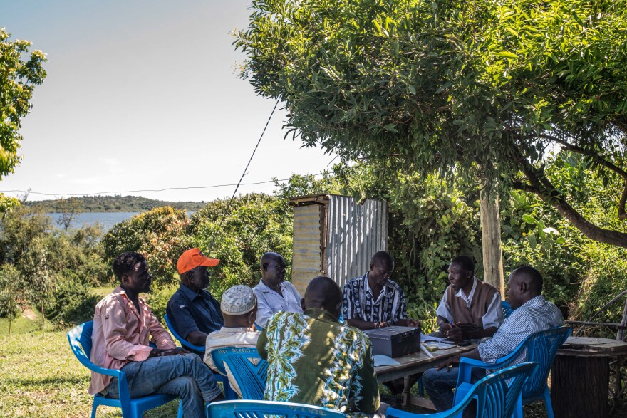 Denis Otieno (third from the right) meets with fellow members of the savings club that he founded after GiveDirectly began providing every adult in the village with monthly cash aid.