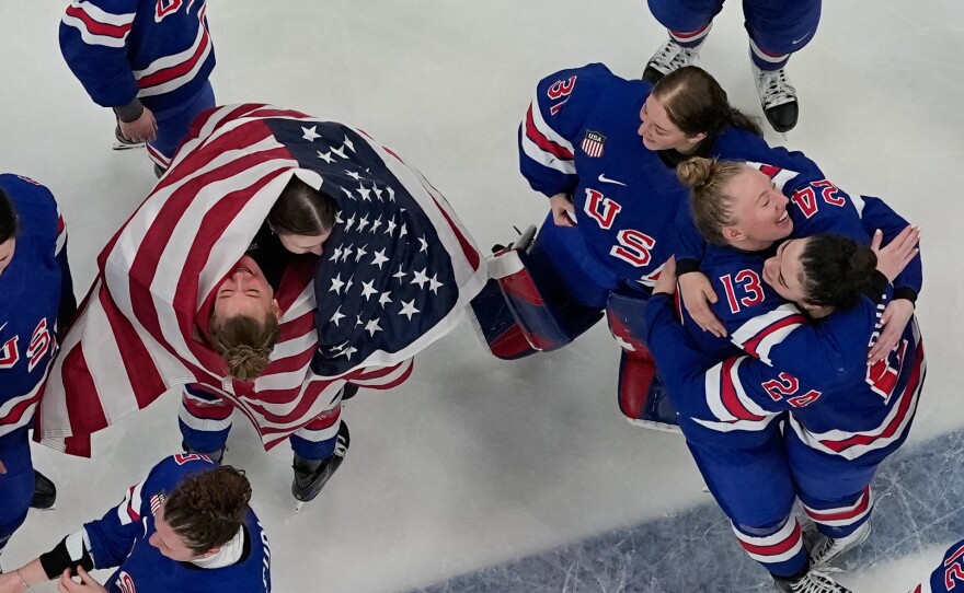 Team United States players celebrate after beating Canada 2-1 in overtime in the women's ice hockey gold medal game at the 2026 Winter Olympics, in Milan, Italy, on Thursday, Feb. 19, 2026.