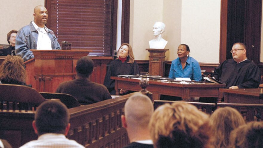 Circuit Clerk Paula Joslin, left, Clark Circuit Judge Jean Chenault Logue, guest speaker Tayna Fogle and District Judge Earl-Ray Neal look on as drug court graduate Herbert Beasley talks to fellow graduates