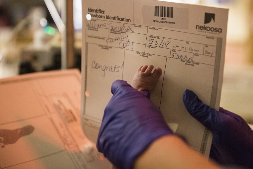 A nurse transfers Mason Williams' footprint onto a birth document.