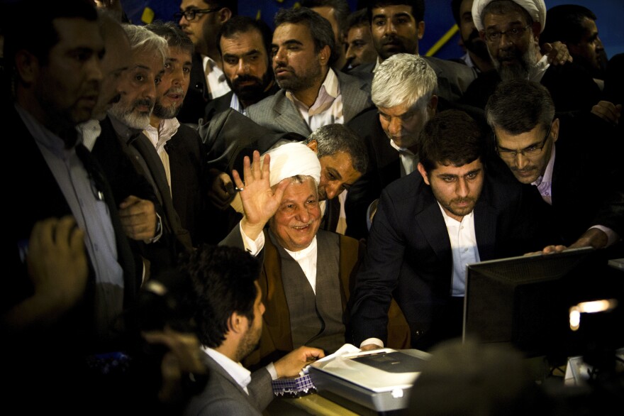 Former Iranian President Ali Akbar Hashemi Rafsanjani (center) waves as he registers his candidacy for the upcoming presidential election at the interior ministry in Tehran, May 11. Rafsanjani has been isolated since massive street protests in 2009 after the disputed re-election of President Mahmoud Ahmadinejad.