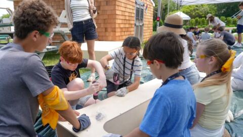Students work on a project at an Alpha School summer camp in the Hamptons. Alpha School advertises 2-hour, daily learning blocks customized by AI followed by hands-on projects and life skills lessons. It's on track to open locations in Edmond and Tulsa this fall.
