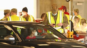A member of the Indiana National Guard greets a patient during the mass COVID-19 vaccination clinic at the Indianapolis Motor Speedway on Friday, March 5.
