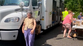 Jean Della Rocca, 66, from East Hartford, at a mobile Foodshare pantry in Glastonbury, Connecticut on July10th 2024. A high-school volunteer carried her bread and fresh veggies to her brother's car. Rocca lives with her mother and brother. She retired after a career spanning 23 years at the Hartford Institute of Living, but said despite saving money she still needs assistance for her food.