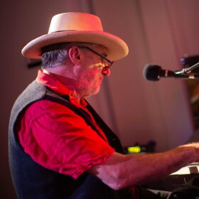 A person plays the piano inside a studio. 