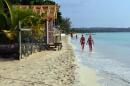 Sunbathers walk along a badly eroding patch of resort-lined crescent beach in Negril in western Jamaica. (David McFadden/AP)