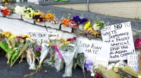Flowers, candles and signs are displayed at a makeshift memorial on Friday, March 19, 2021, in Atlanta. (Candice Choi/AP Photo)
