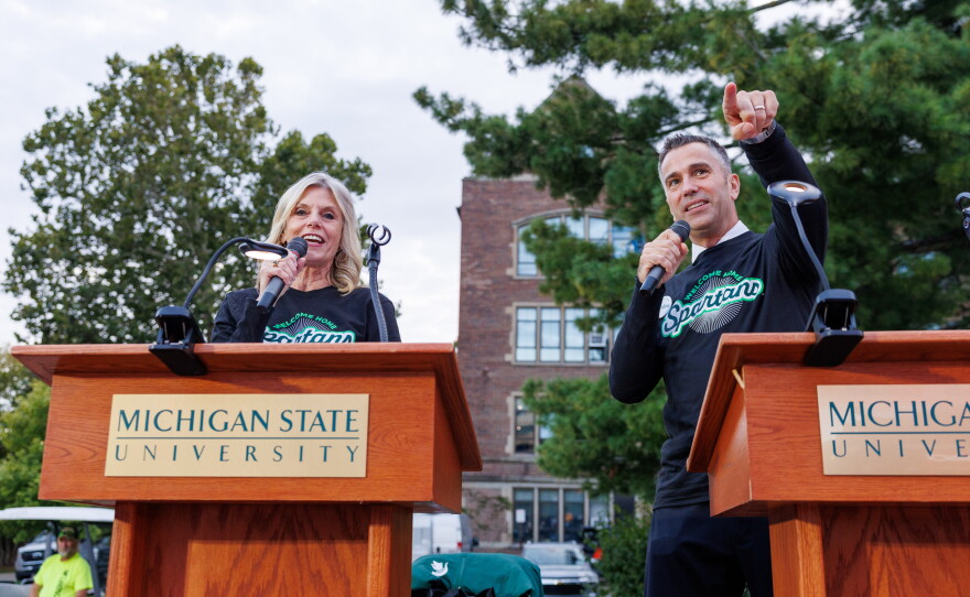 WKAR's Sheri Jones, left, and WIS-TV Evening Anchor Greg Adaline, right, emcee the Michigan State University Homecoming Parade in East Lansing, Mich., on Oct. 9, 2026.
