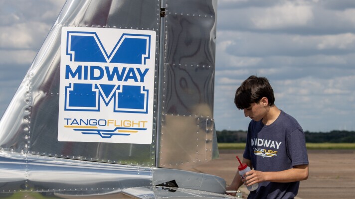 A Midway High School Tango Flight capstone student cleans the completed airplane before a celebration ceremony and public viewing on Wednesday, May 20. The students built the plane over the course of two years.