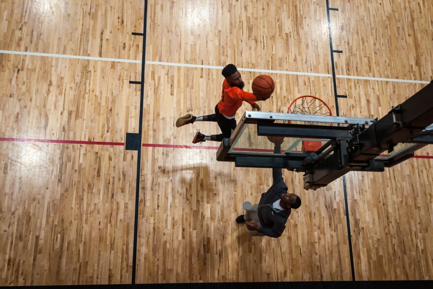 Darrius Johnson, 26, makes a layup with Adam Walker, 31, before their pick-up game Saturday at Monsanto Family YMCA.