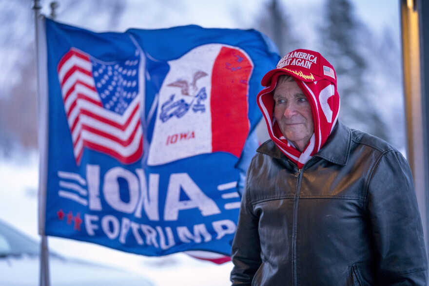 A man stands next to a flag that reads "Iowa for Trump" outside the the Machine Shed in Urbandale, Iowa on Thursday.