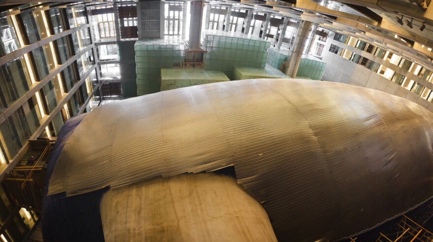 The bluish metal "skin" of La Ballena Azul (the "Blue Whale"), still under construction. The concert hall is three stories high and actually "floats" — it is mounted on shock-absorbing stilts to protect it from vibrations from the subway nearby.