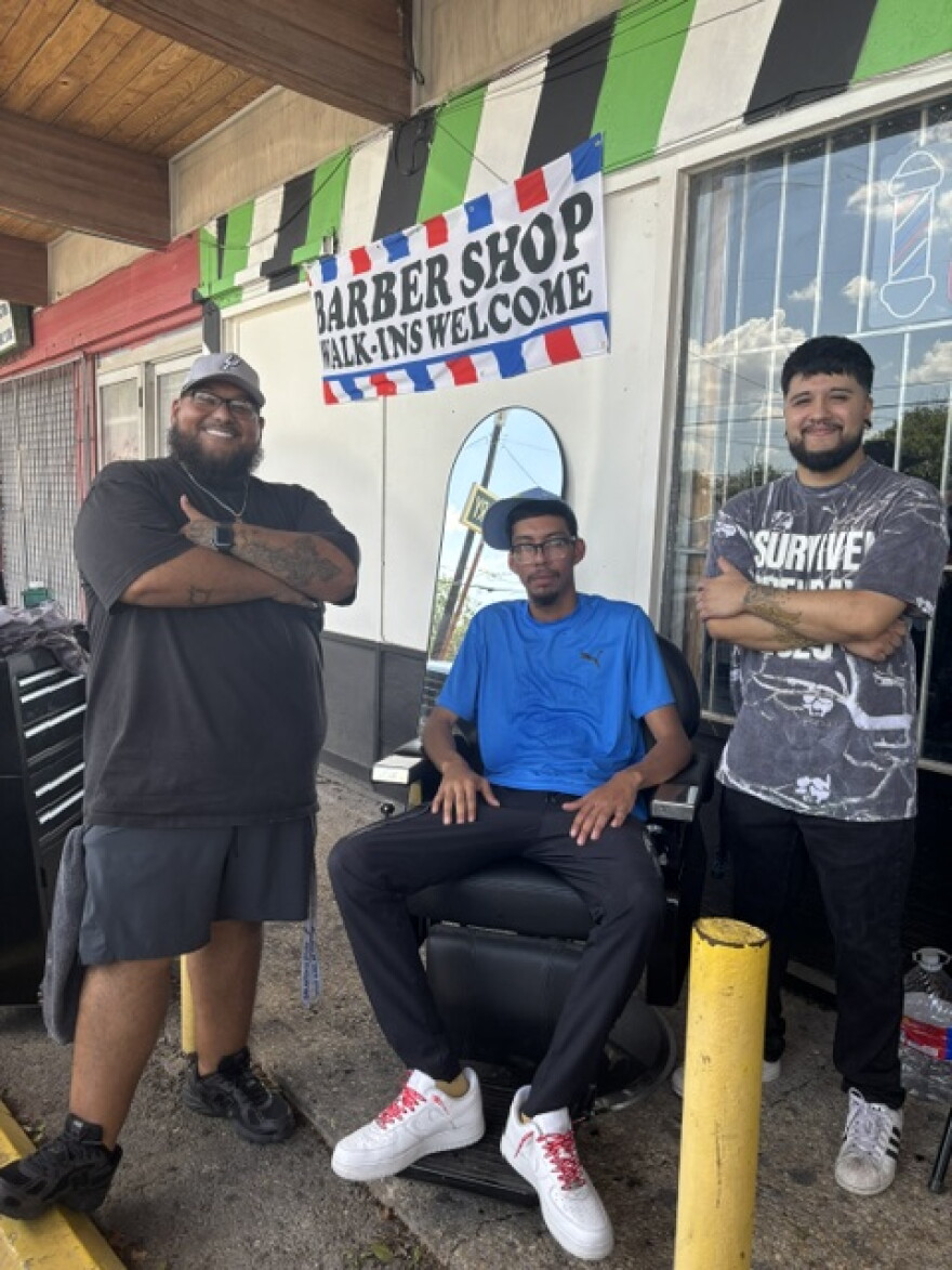 Juan Martinez (left) and two of the barbers from the Misfit barbershop. The West Side business stayed open even though they'd been without electricity since the night before. Aug. 29,2026