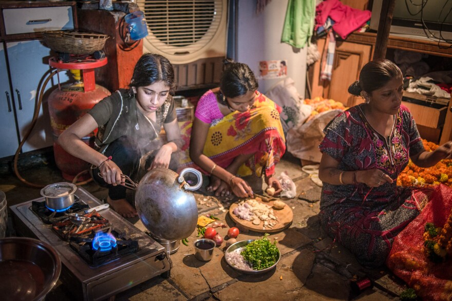 Aniket's older sister, Aishwarya (left, with a cousin), prepares a meal. Her mother, Rekha Sathe (right, stringing garlands for the family business), started teaching her daughter to cook at age 10 to prepare her for married life.