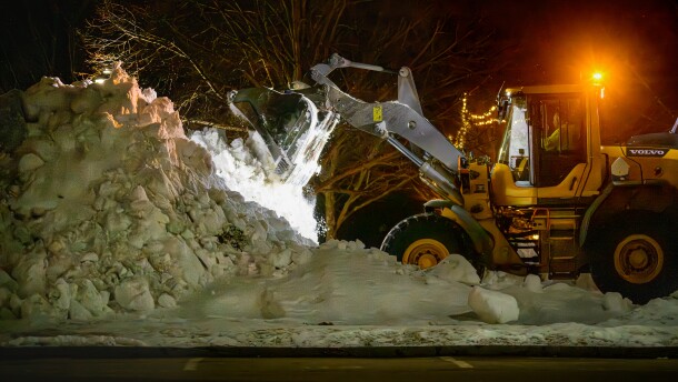 On Sunday evening, as flakes from the coming storm began to fall, a hill of snow from last month's accumulation is made higher by snow removal equipment at E.O. Smith High School in Mansfield, Ct. Forecasters are predicting more than a foot of snow will fall through Monday with wind gusts as high as 55 mph.