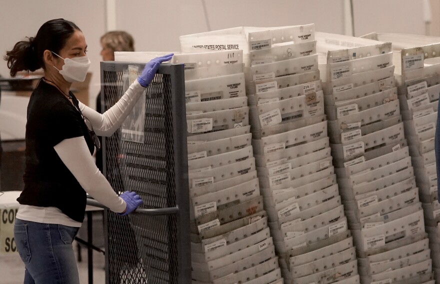 An election worker arrives with ballots to be tabulated inside the Maricopa County recorder's office in Phoenix on Wednesday.