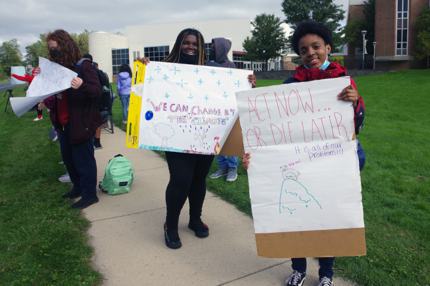 students standing outside holding protest signs