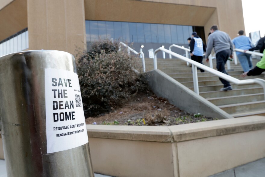 North Carolina fans file into the building beside a "Save the Dean Dome" sticker before an NCAA college basketball game against Clemson, Tuesday, March 3, 2026, in Chapel Hill, N.C.