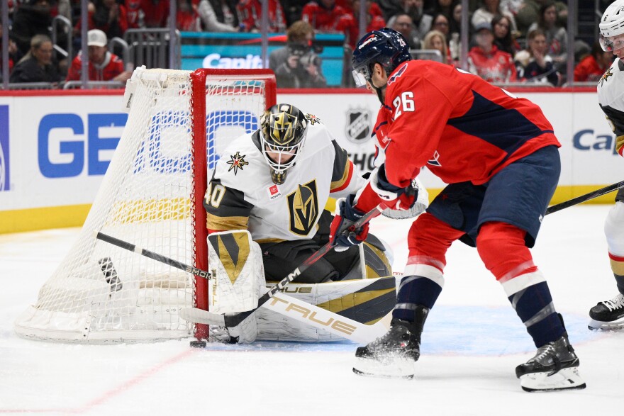 Washington Capitals center Nic Dowd (26) tries to get the puck past Vegas Golden Knights goaltender Akira Schmid (40) during the first period of an NHL hockey game, Friday, Feb. 27, 2026, in Washington. (AP Photo/Nick Wass)