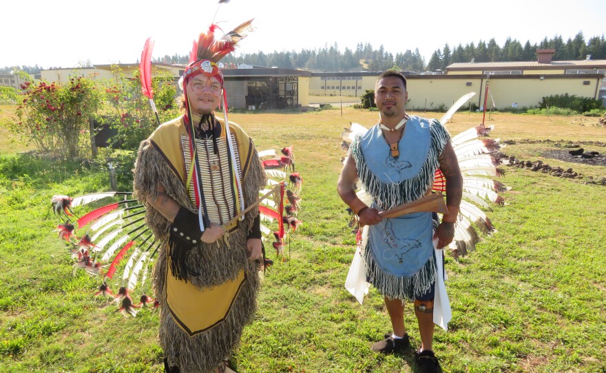 Two smiling men in powwow regalia. 