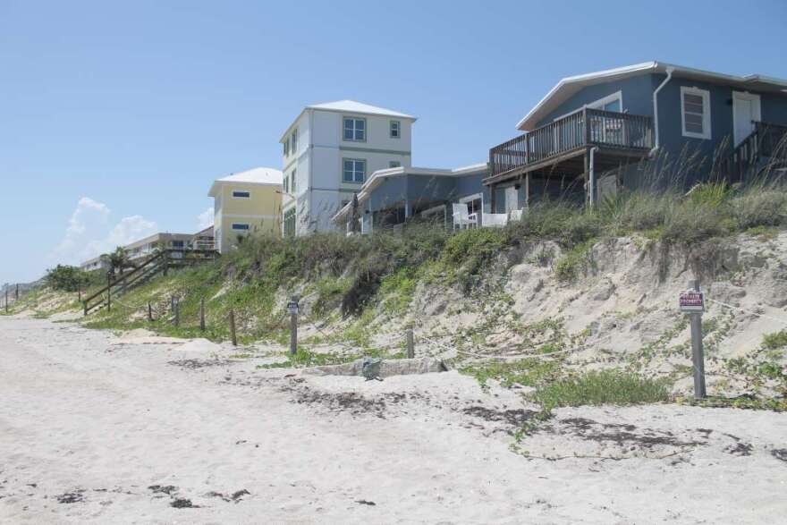 In Satellite Beach homes perch atop a sand dune, left exposed after a series of storms and hurricanes washed away a sea wall. Photo by Amy Green