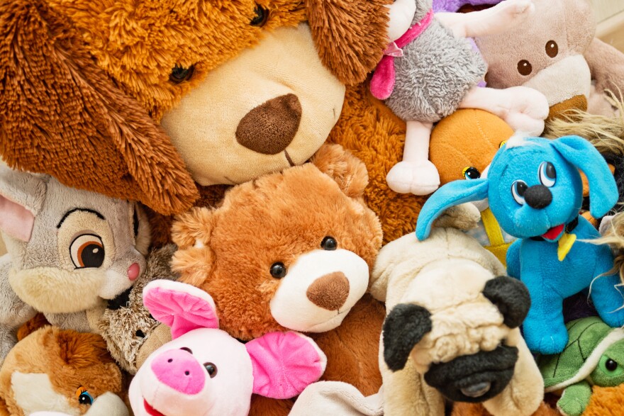 Many Soft plush fluffy toys sits on the floor in the children's room