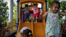 Metea Tilden hangs from the slide at the Affton Early Childhood Center Tuesday, Aug. 13, 2019, on her first day of school.