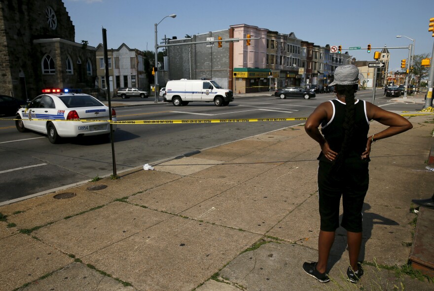 A resident in the neighborhood where Freddie Gray was arrested and where residents rioted over his death in April looks on at the scene of a shooting at the intersection of West North Avenue and Druid Hill Avenue in West Baltimore, Md., on May 30.