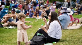 A picture of a mother and daughter playing with bubbles at KPCW's Back Alley Bash August 2025
