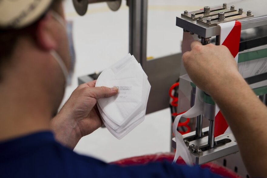 a worker handles filter material for face masks