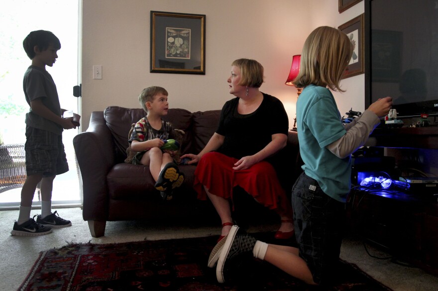 Moritz plays with her sons (from left) Elliot, 8, Ariel, 6, and Aidan in their apartment. The children also have had health problems since their father's accident.