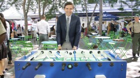 Joshua Curtis stands behind a foosball table.