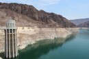 Lake Mead sits behind an intake for Hoover Dam, showing a stark white bathtub ring on red canyon walls.