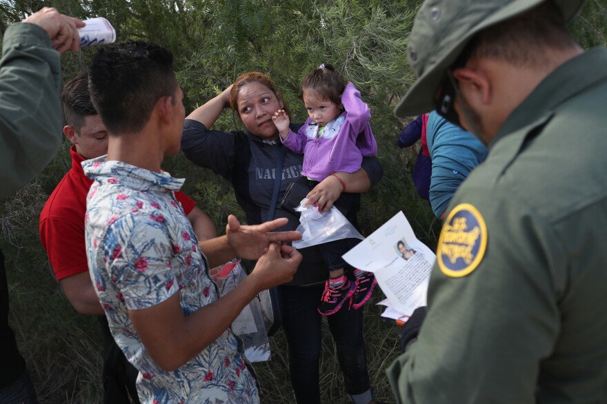 U.S. Border Patrol agents ask a group of Central American asylum seekers to remove hair bands and wedding rings before taking them into custody on June 12, near McAllen, Texas.