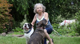 Marianne Anniszkiewicz sitting in her lawn with her two dogs, Oliver and Abigail