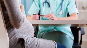 A pregnant mother meets with her doctor. 