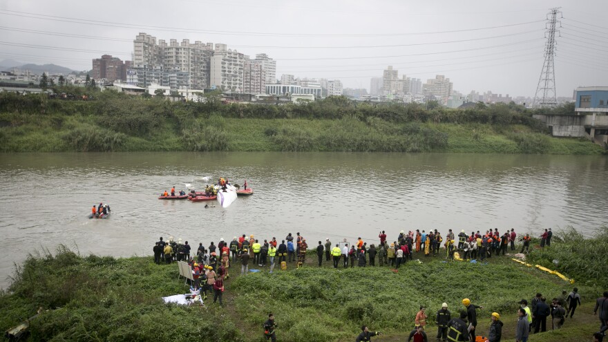 Rescue teams work to free people Wednesday from a TransAsia Airways ATR 72-600 turboprop airplane that crashed into the Keelung River shortly after takeoff from Taipei Songshan Airport in Taiwan.
