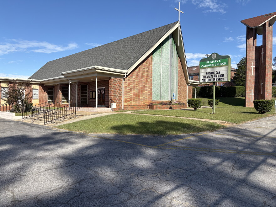 A church building with a steeple at the apex of the room. A sign in front of the church reads "Nothing can separate us from the love of Christ."