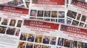 Seeking information flyers produced by the FBI are photographed on Dec. 20, 2021. The Justice Department has undertaken the largest investigation in its history with the probe into rioters who stormed the Capitol on Jan. 6. (AP Photo/Jon Elswick)