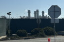 Smoke rises above industrial towers