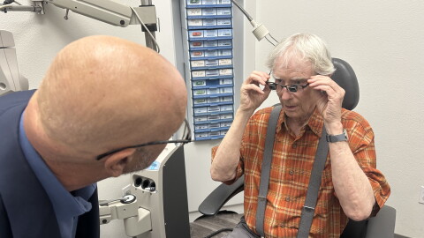 Dr. Andrew Bock checks the specialized glasses worn by Julian Dean of Santa Barbara.