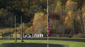 An American flag is set to half mast Saturday on a football field in Lisbon Falls, Maine, just a few hundred yards from a recycling facility where law enforcement found the body of Robert Card, the suspect in this week's mass shootings.